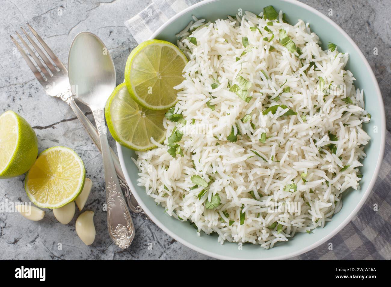 Homemade Mexican Cilantro Lime Rice closeup on the bowl on the marble table. Horizontal top view from above Stock Photo
