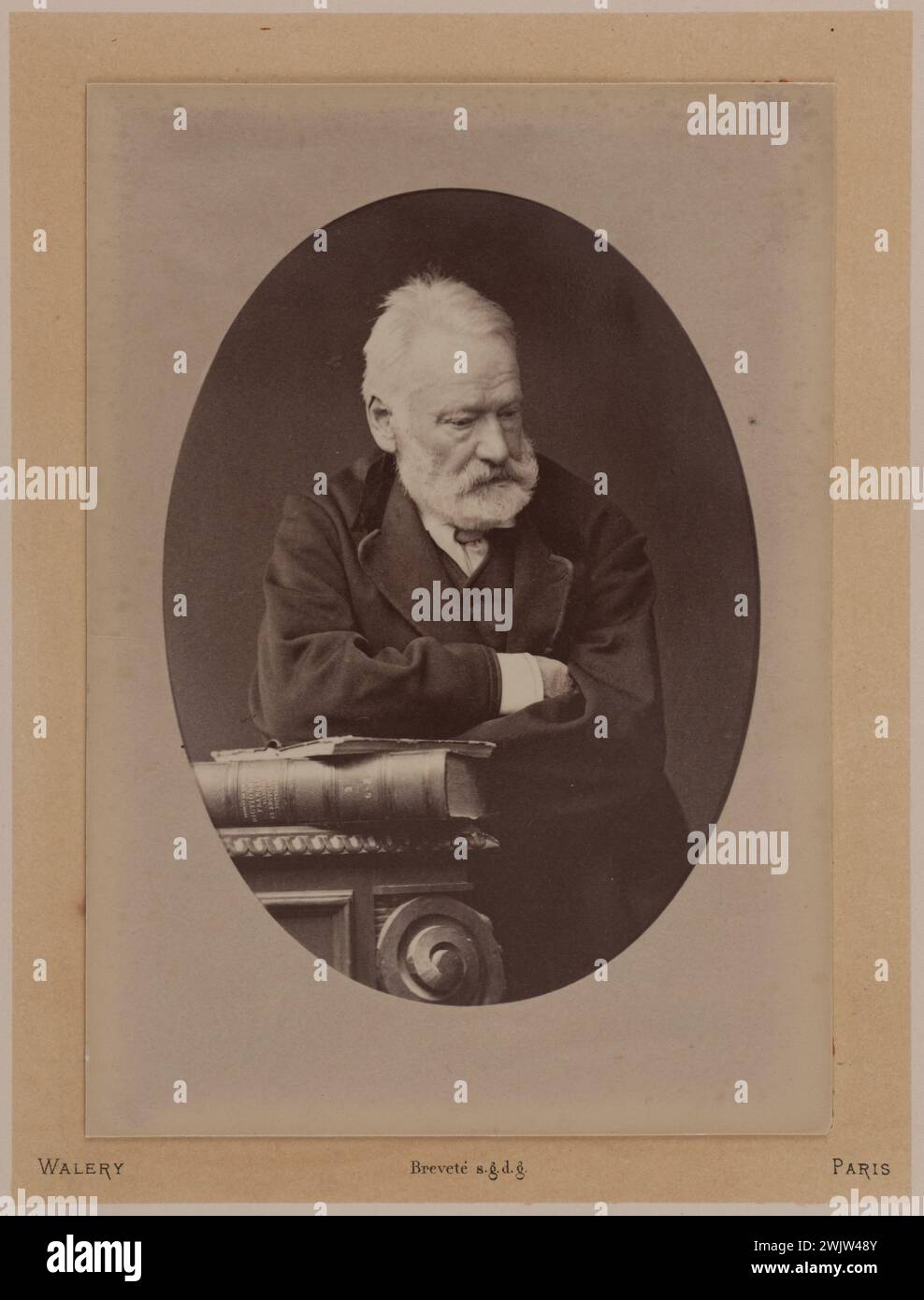Lucien Waléry (1830-1890). Victor Hugo Standing based on a book placed on a table. EPREOVE on albumin paper, 1879. Paris, Maison de Victor Hugo. 71161-40 Leaning, standing, French writer, book, laying, portrait, table Stock Photo