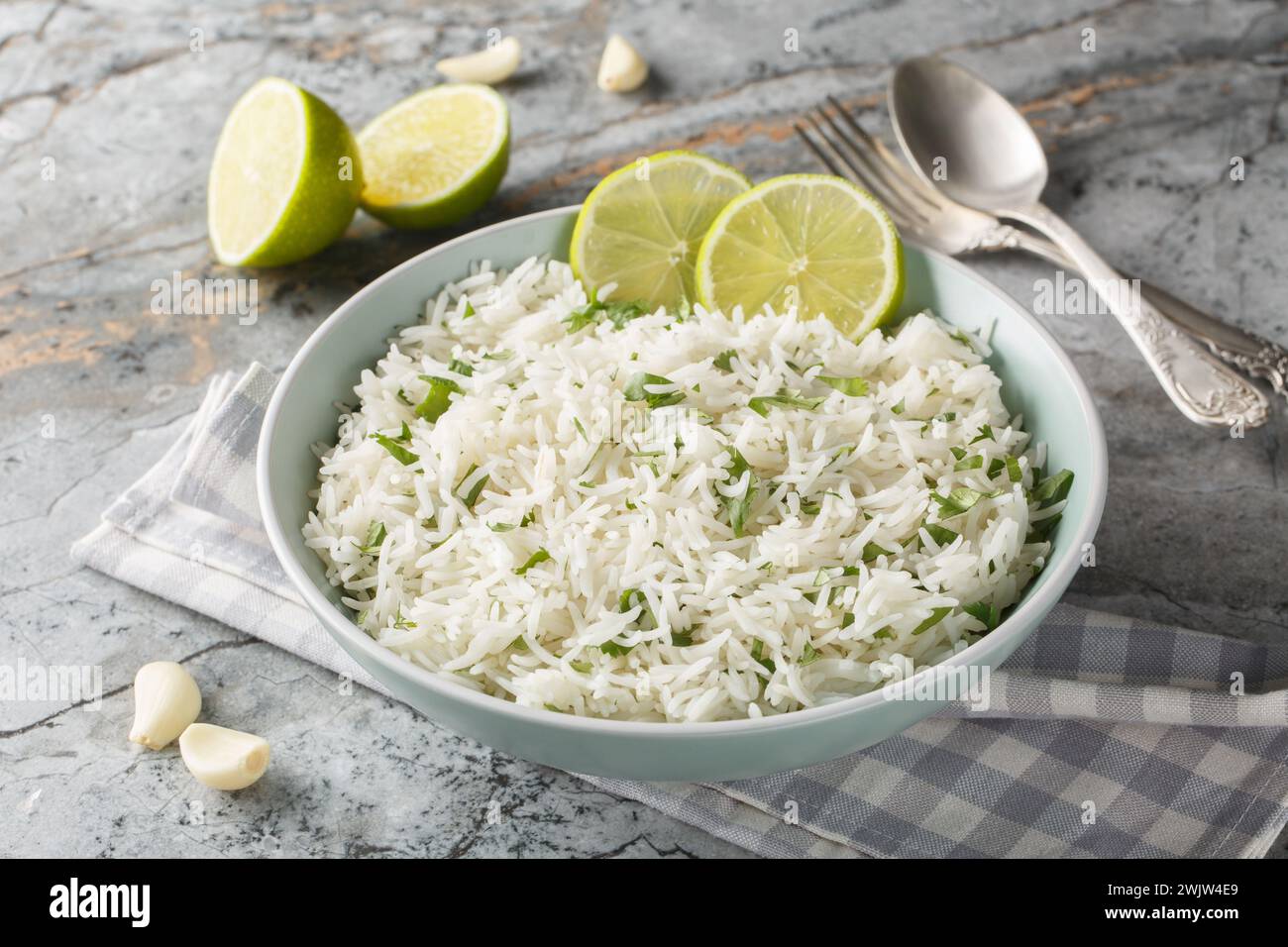 Delicious rice with garlic, cilantro, lime and zest close-up in a bowl on the table. Horizontal Stock Photo