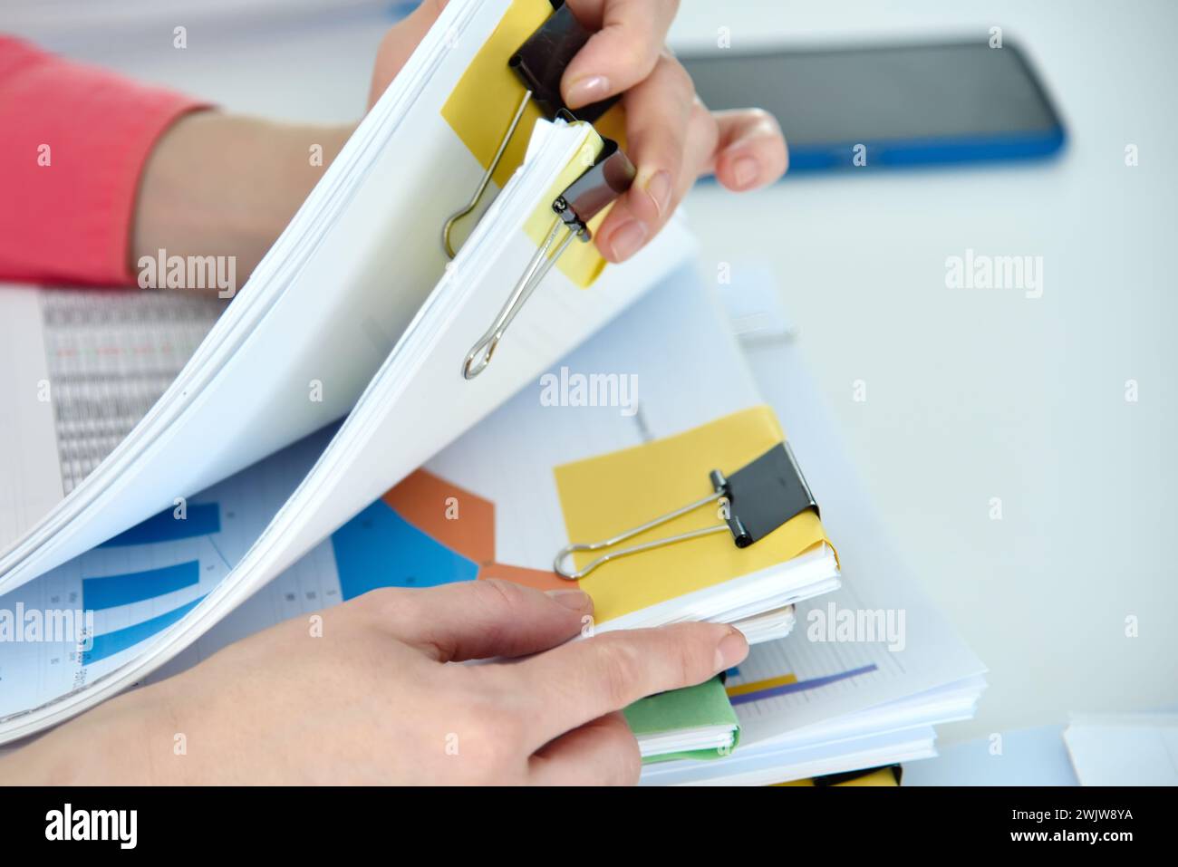 Businesswoman hands holding business reports stacks and stock charts. Financial and paperwork concept Stock Photo