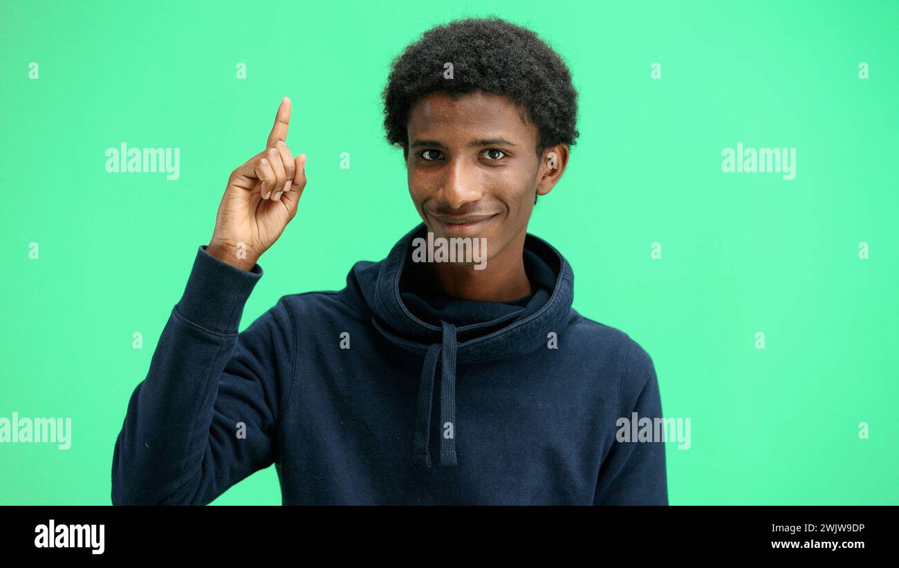 Man, close-up, on a green background, pointing up Stock Photo
