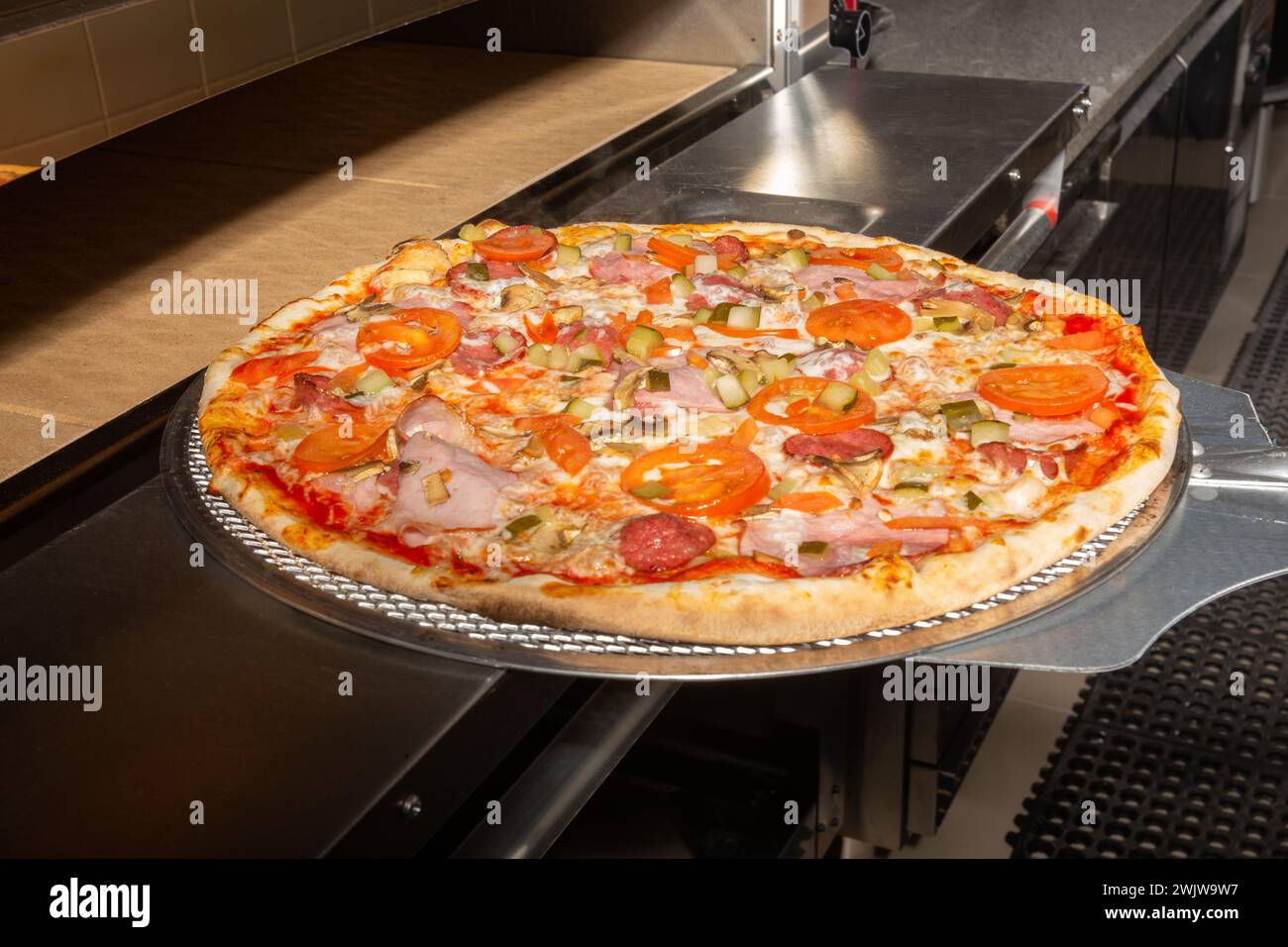 Pizzajello cook putting pizza in electric oven in a pizzeria, extra
