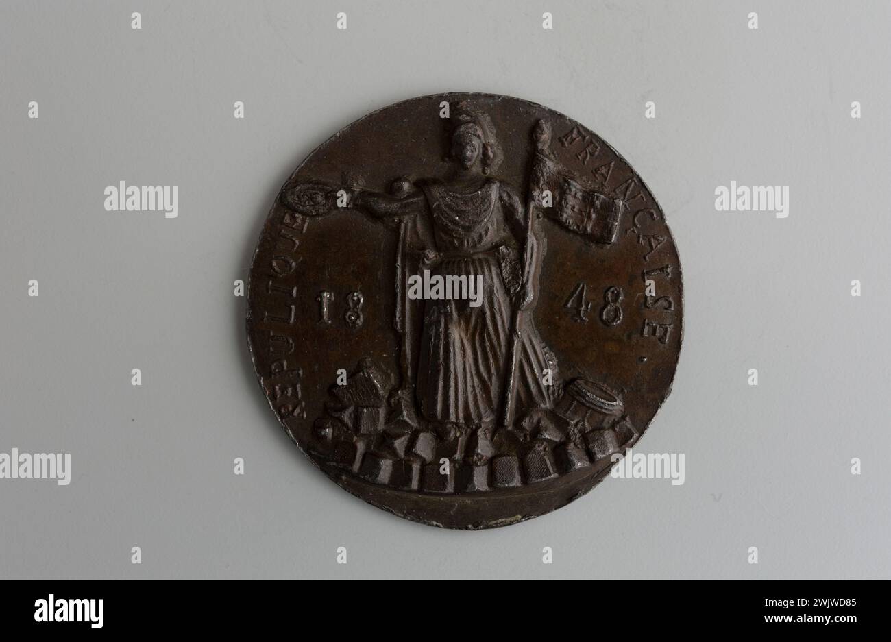 Carnavalet museum, medal collection Right the Republic at the foot from the front on a barricade, tending from the right arm a crown of victory and the shaft of a flag in its left hand; Reverse registration on two lines. Stock Photo