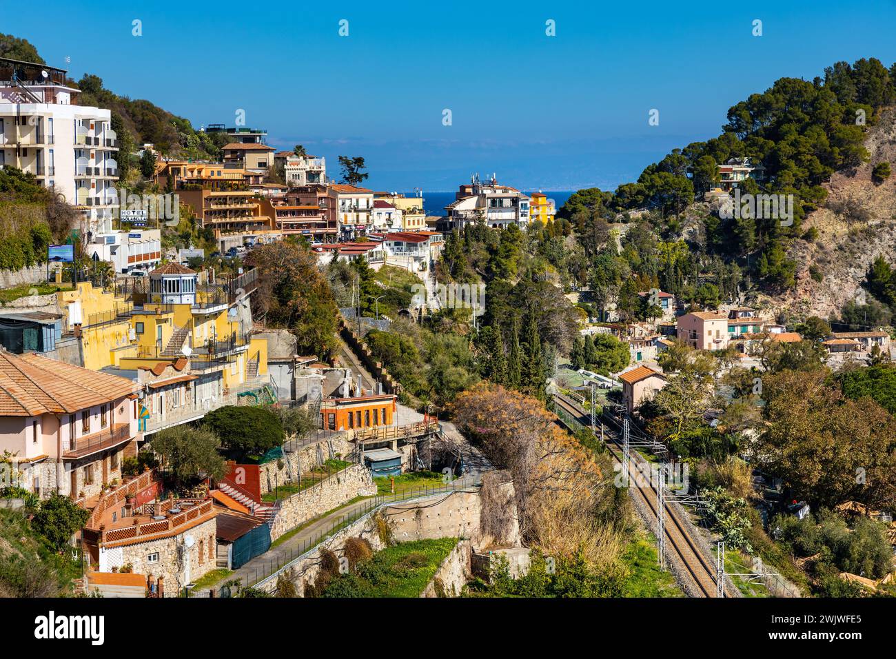 Taormina, Sicily, Italy - February 15, 2023: Panoramic view of Taormina and Mazzaro town at Ionian sea shore seen from Funivia Cable Car gondola Stock Photo
