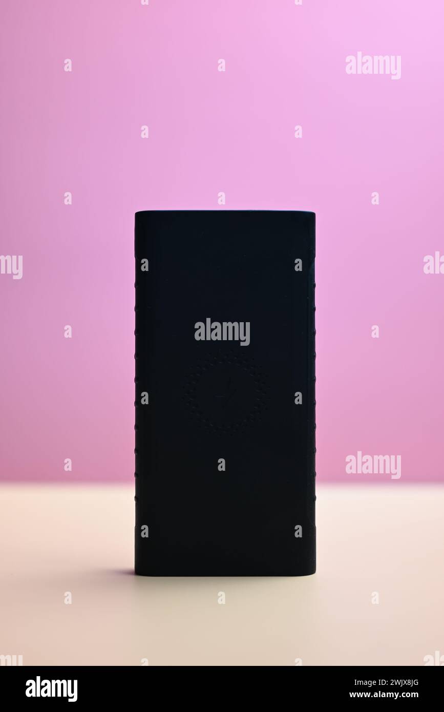 black battery for smartphone on orange and pink background Stock Photo