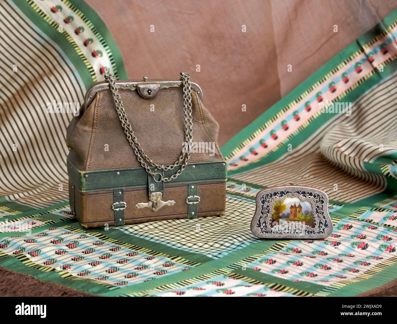 Shawl, travel bag and wallet. Shawl: brown silk gauze, brown silk brown gray purple green, fringes in brown silk. Bag: Brown leather with ornament in brown leather and silver metal, clasp with steel click in steel, double steel chain handle bréguet, red leather lining, double red moiré background maintained by flange and lock, small storage flanges The interior. Silver: In silver cut on black silk background framing a glass paint. 1855-1860. Galliera, fashion museum of the city of Paris. Chale, travel bag and wallets Accessory, chale, brown leather, female, argente metal clasp, fringe, gauze, Stock Photo