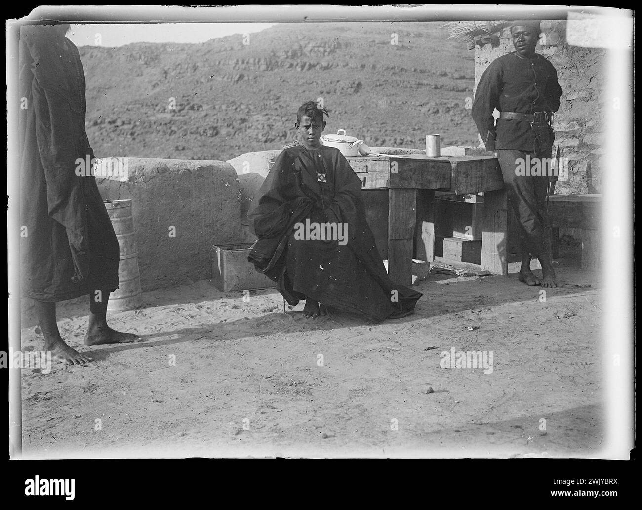 Character dressed in a large draped, sitting between two men standing by his side (username). Glass photographic plate. Museum of Romantic Life. Stock Photo