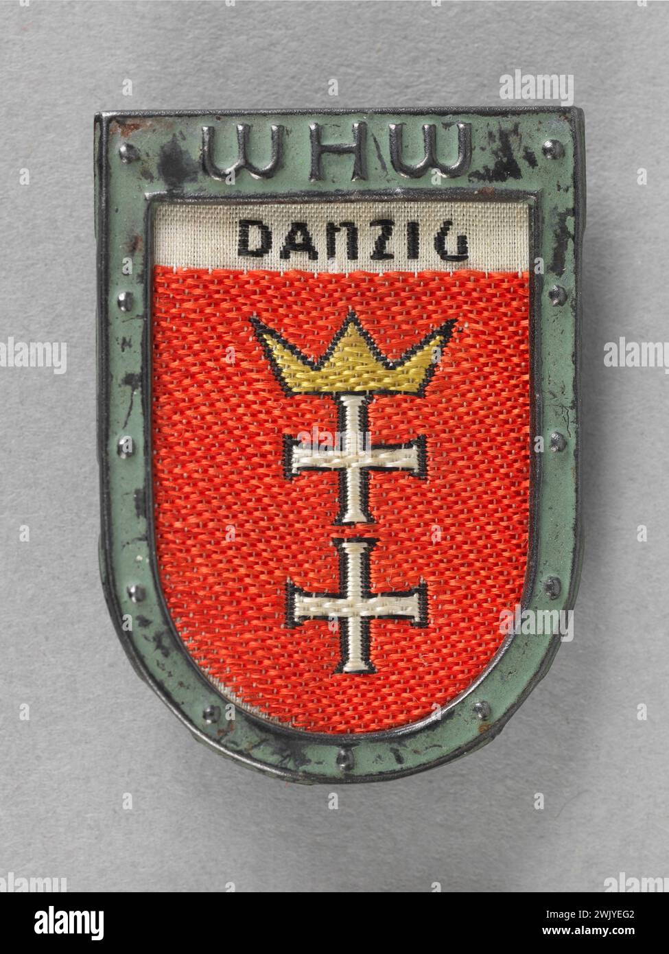 Winterhilfswerk des Deutschen Volkes (WHW) Danzig insignia (Dantzig) handed over during quests for the benefit of the Winterhilfswerk (WHW: Winter help work) (attributed title), 1933. Stamped metal, fabric, painting, cardboard paper. Museum of the Liberation of Paris - General Leclerc Museum - Jean Moulin Museum. Stock Photo