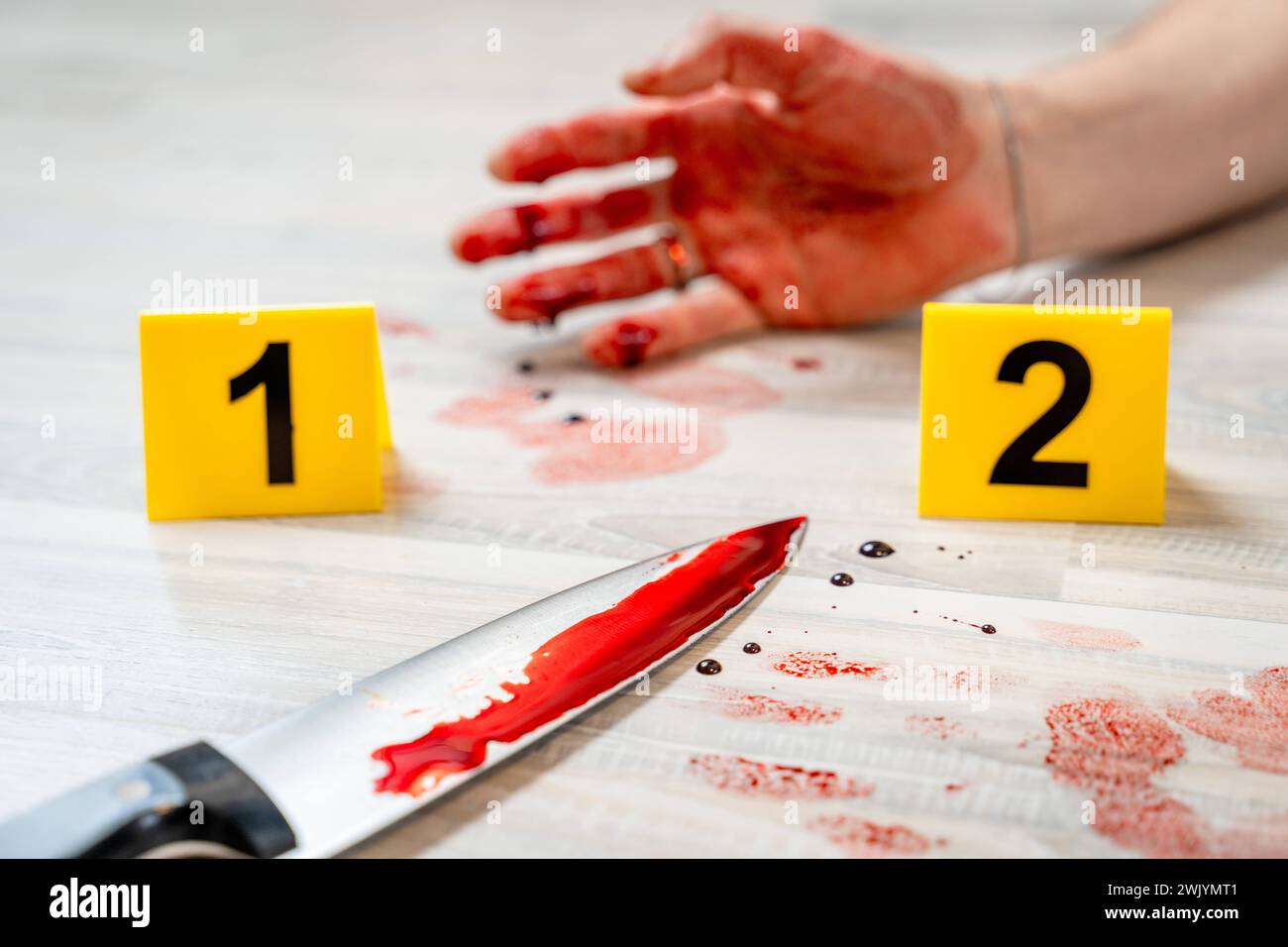 Augsburg, Bavaria, Germany - February 16, 2024: Symbolic image crime scene of a murder case staged scene. Man smeared with blood lying on the ground with police evidence markings *** Symbolbild Tatort eines Mordfalls gestellte Szene. Mit Blut verschmierter Mann liegt auf dem Boden mit Beweismittel Markierungen der Polizei Stock Photo