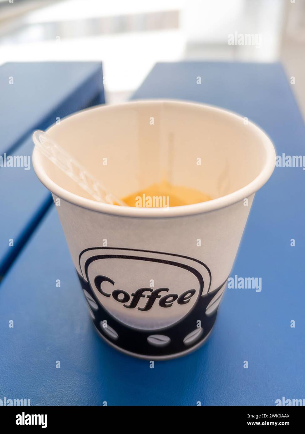 Coffee in vending machine paper cup on blue plane on blurred background ...