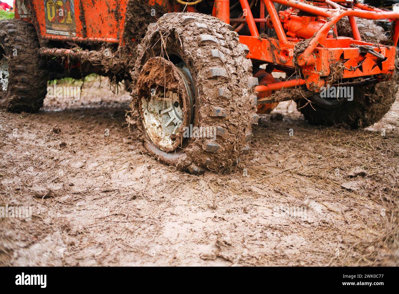 close up of a punctured off road car tire on a muddy road Stock Photo