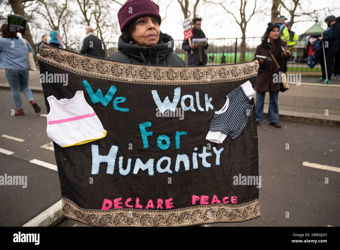 On February 17th 2024 demonstrations were held worldwide demanding a ceasefire in Gaza. Woman with home-made banner with a child's clothes sewn on a s Stock Photo