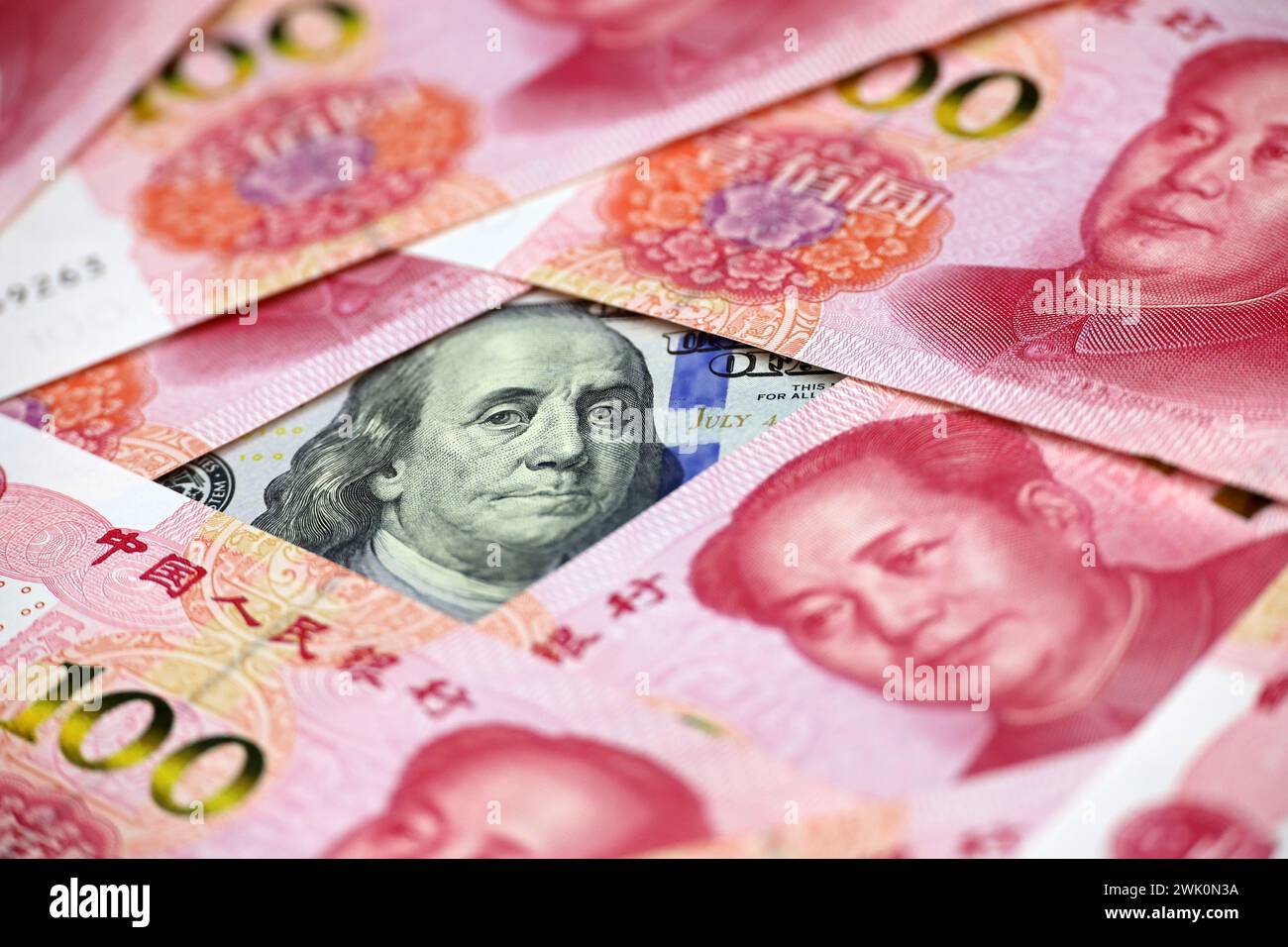 US dollars surrounded by Chinese yuan banknotes. Concept of trade war between the China and USA, economic, sanctions Stock Photo