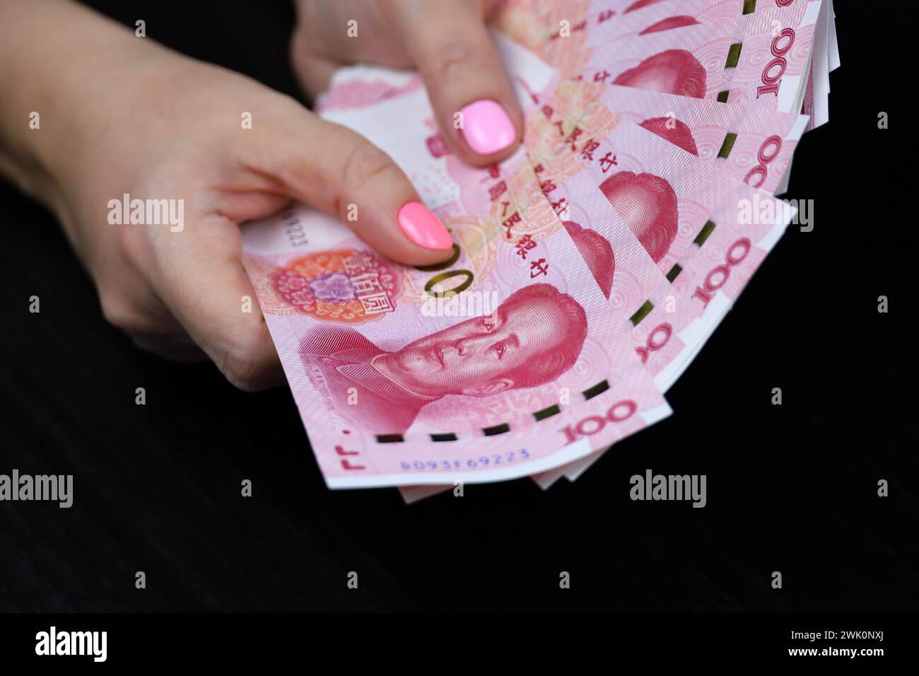 Chinese yuan banknotes in female hands. Woman counting paper money Stock Photo