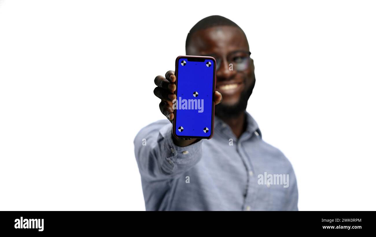 A man, close-up, on a white background, shows a phone Stock Photo