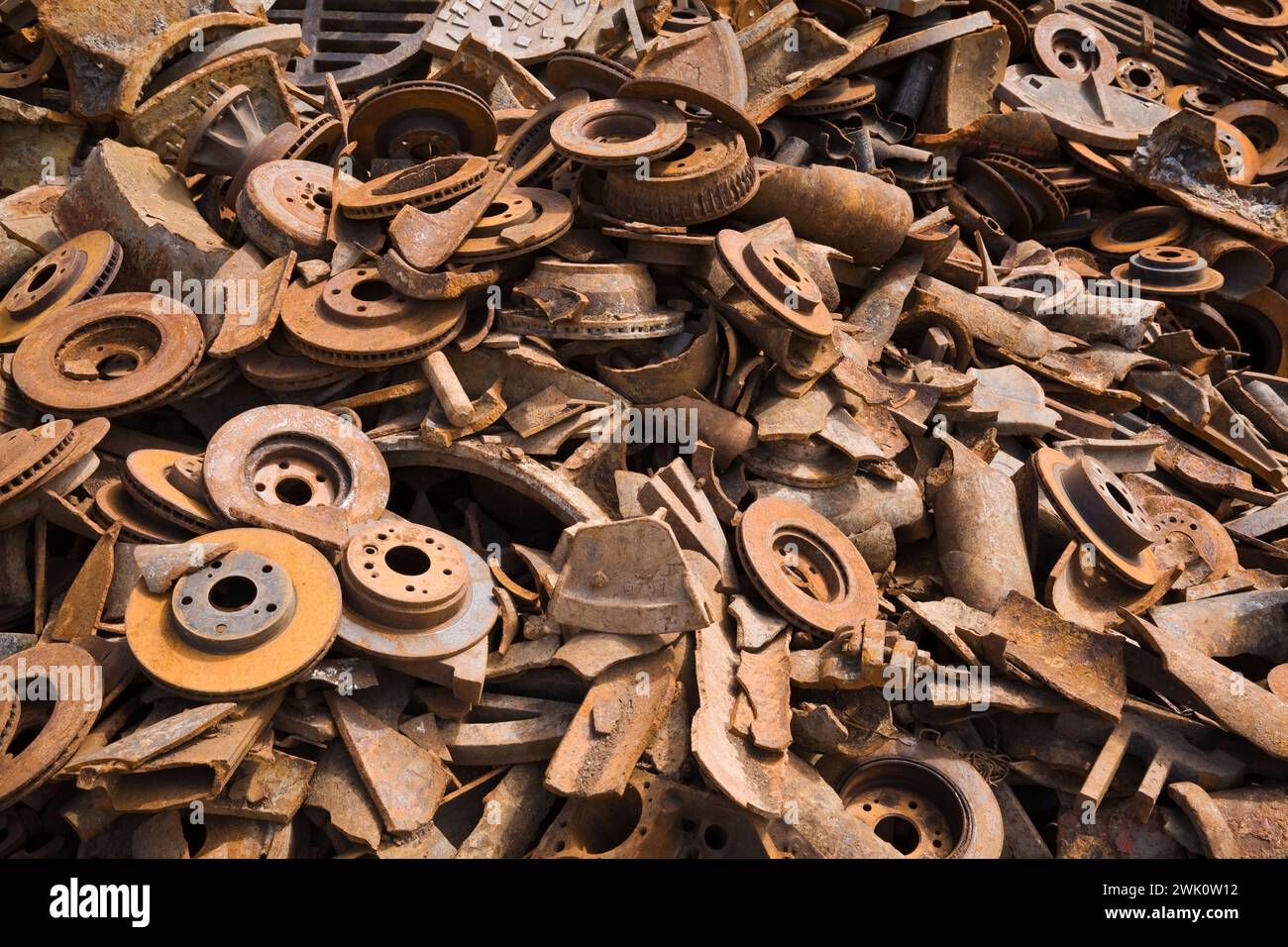 Pile of assorted rusted steel disc and drum brakes at scrap metal