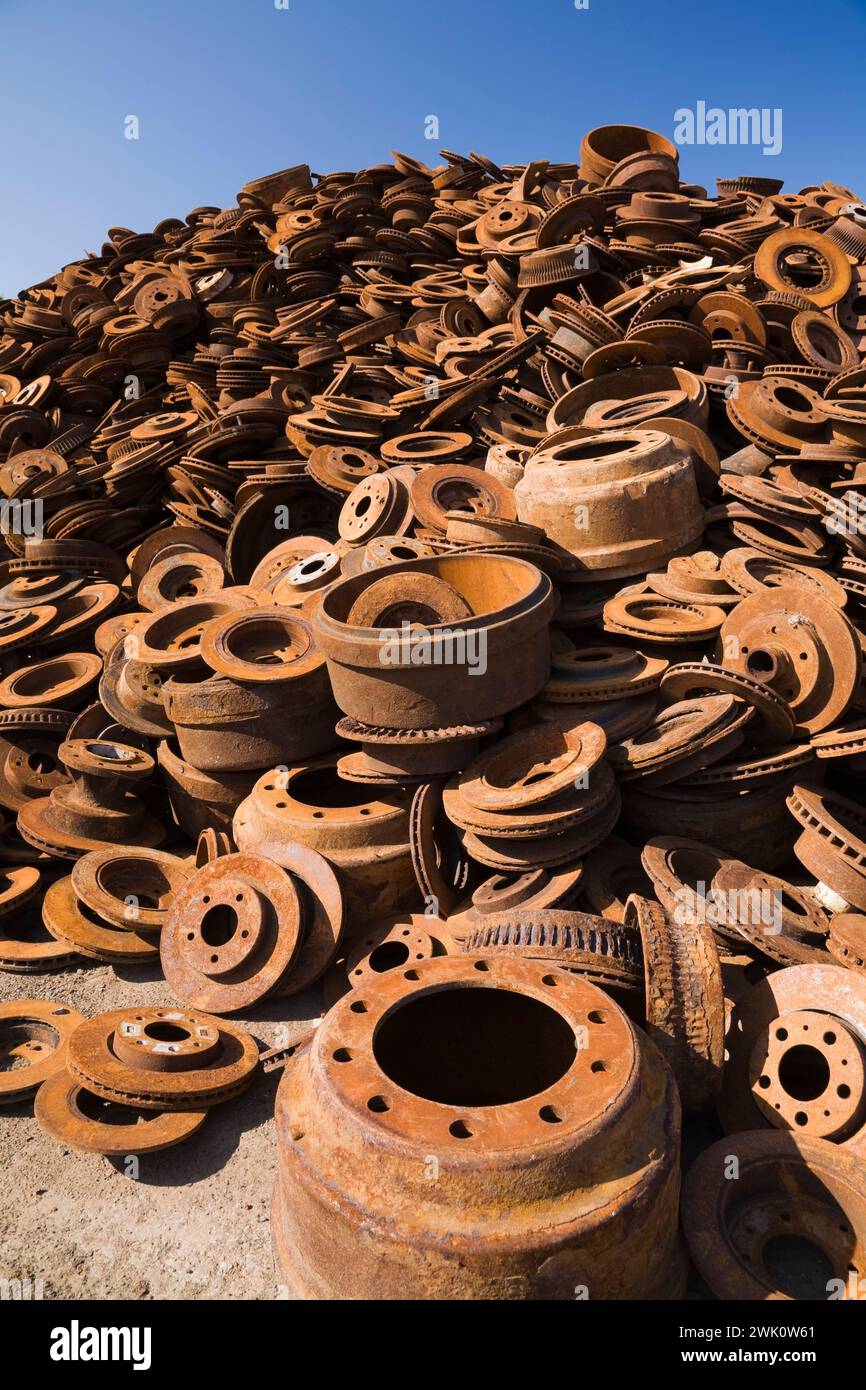 Pile of assorted rusted steel disc and drum brakes at scrap metal recycling junkyard. Stock Photo