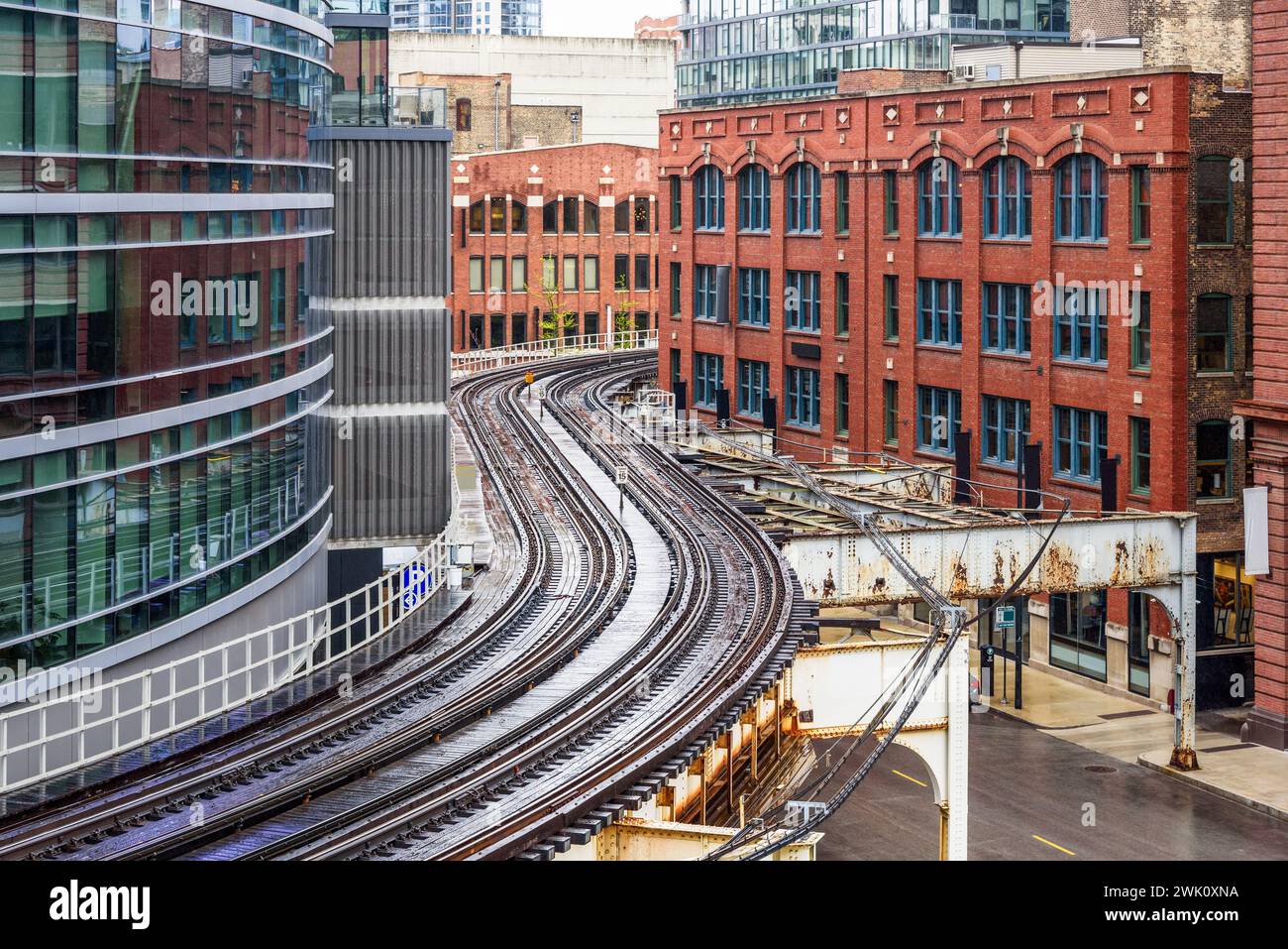 Curving elevated railway between both tradtional and modern buildigs in downtown Chicago on a raining spring day Stock Photo