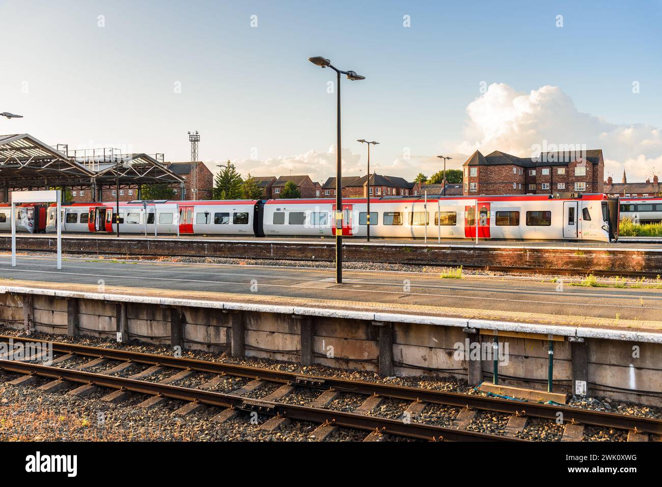 Diesel commuter train in station at sunset Stock Photo