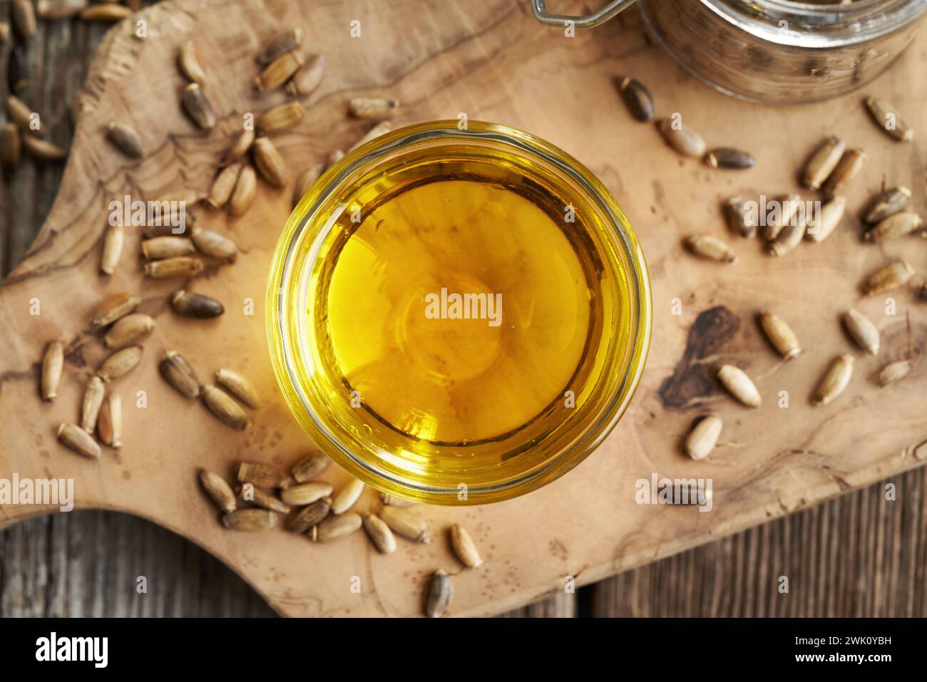Milk thistle oil in a glass bowl with Carduus marianus seeds, top view Stock Photo