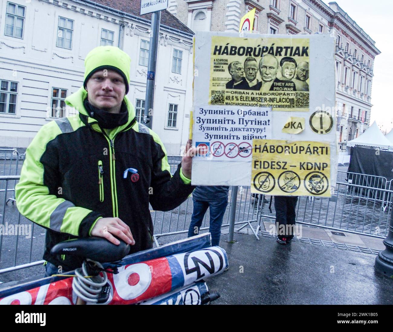 Budapest, Budapest, Hungary. 17th Feb, 2024. A Hungarian activist with his bike, holds sign saying War Party in front of Varkert, where Hungarian Prime Minister VIKTOR ORBAN made his annual speech and comments on three resignations of Hungarian President, KATALIN NOVAK; former Minister and leadership of Hungarian Reform Church, ZOLTAN BALOG and former Justice Minister, JUDIT VARGA following exposure of a man pardoned last year from covering up pedophilia in a children's home. The reveal has caused embarrassment and tarnished the image of Hungary's safe zone and high family value image. Stock Photo