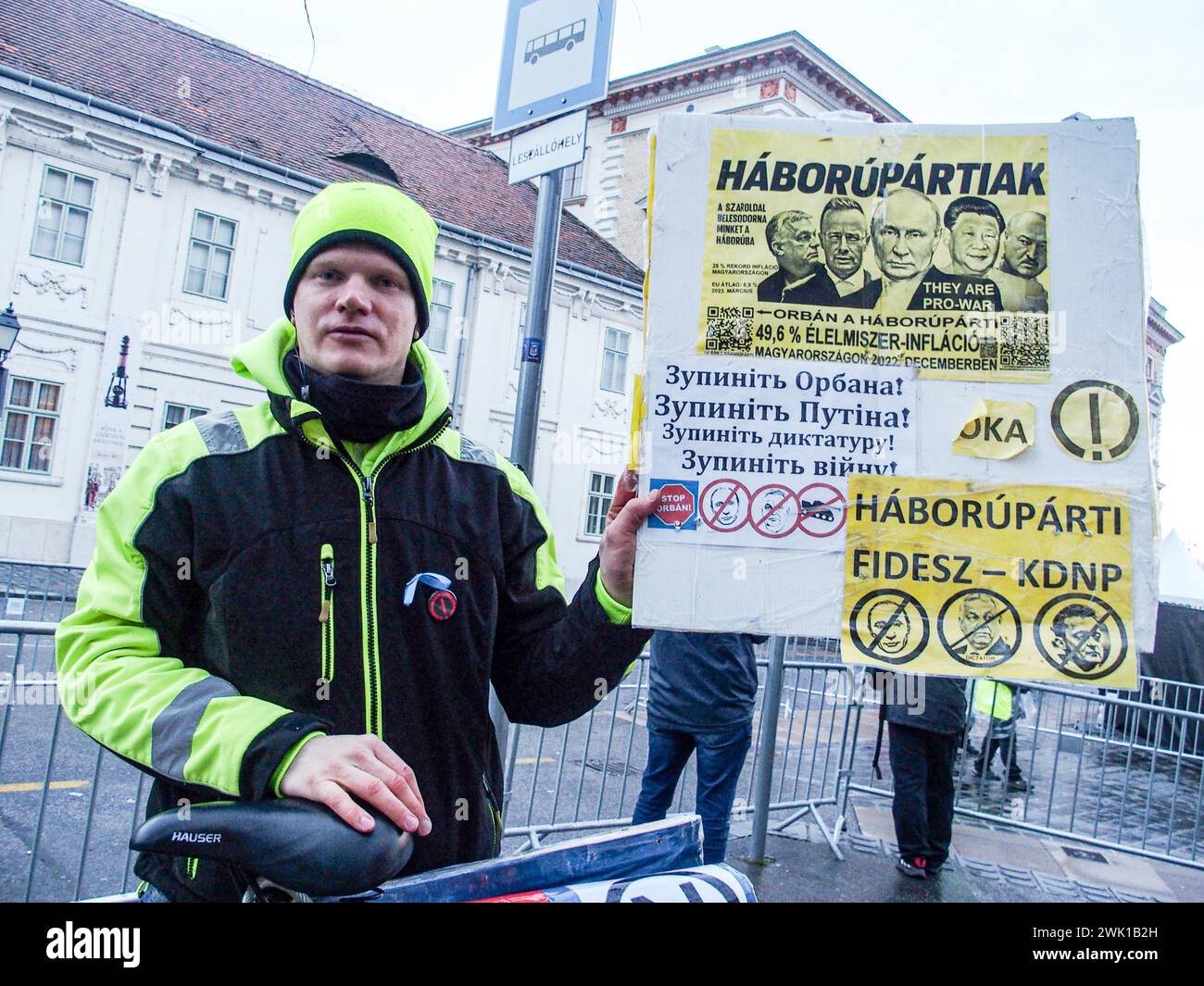 Budapest, Budapest, Hungary. 17th Feb, 2024. A Hungarian activist with his bike, holds sign saying War Party in front of Varkert, where Hungarian Prime Minister VIKTOR ORBAN made his annual speech and comments on three resignations of Hungarian President, KATALIN NOVAK; former Minister and leadership of Hungarian Reform Church, ZOLTAN BALOG and former Justice Minister, JUDIT VARGA following exposure of a man pardoned last year from covering up pedophilia in a children's home. The reveal has caused embarrassment and tarnished the image of Hungary's safe zone and high family value image. Stock Photo