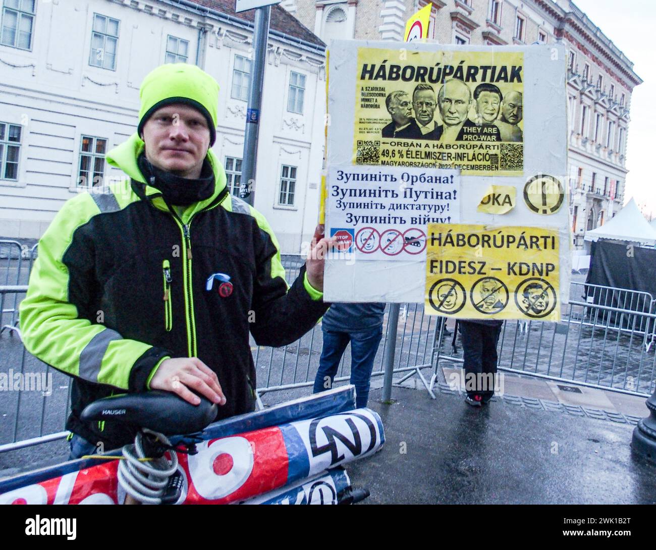 Budapest, Budapest, Hungary. 17th Feb, 2024. A Hungarian activist with his bike, holds sign saying War Party in front of Varkert, where Hungarian Prime Minister VIKTOR ORBAN made his annual speech and comments on three resignations of Hungarian President, KATALIN NOVAK; former Minister and leadership of Hungarian Reform Church, ZOLTAN BALOG and former Justice Minister, JUDIT VARGA following exposure of a man pardoned last year from covering up pedophilia in a children's home. The reveal has caused embarrassment and tarnished the image of Hungary's safe zone and high family value image. Stock Photo