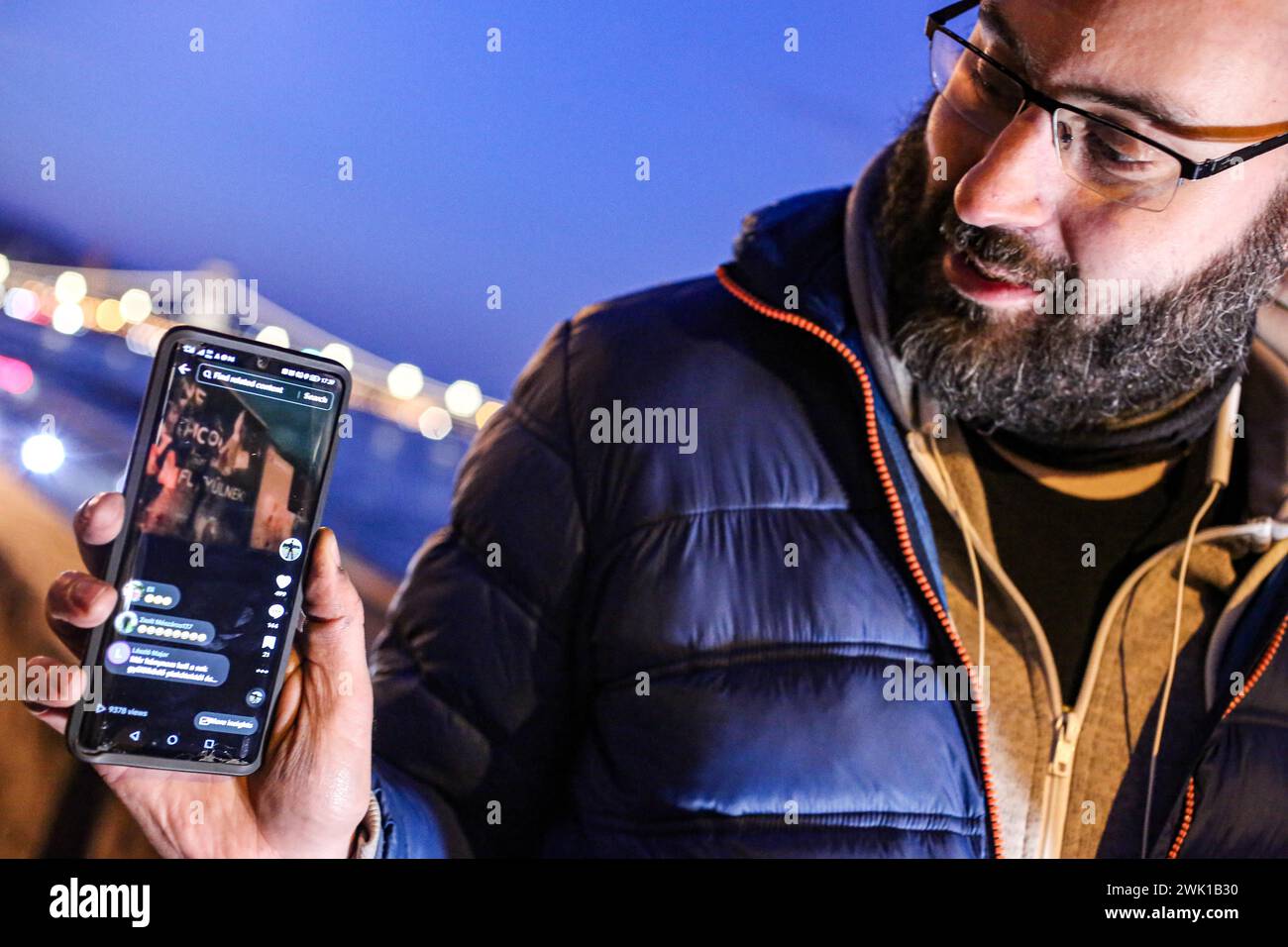 Budapest, Budapest, Hungary. 17th Feb, 2024. Hungarian activist, Balasz T., holds a phone demonstrating efforts by other activists and influencers the day after a massive protest took place in the capital towards Hungarian Prime Minister VIKTOR ORBAN and on the three resignations of Hungarian President, KATALIN NOVAK; former Minister and leadership of Hungarian Reform Church, ZOLTAN BALOG and former Justice Minister, JUDIT VARGA following exposure of a man pardoned last year from covering up pedophilia in a children's home. The reveal has caused embarrassment and tarnished the image of Hu Stock Photo