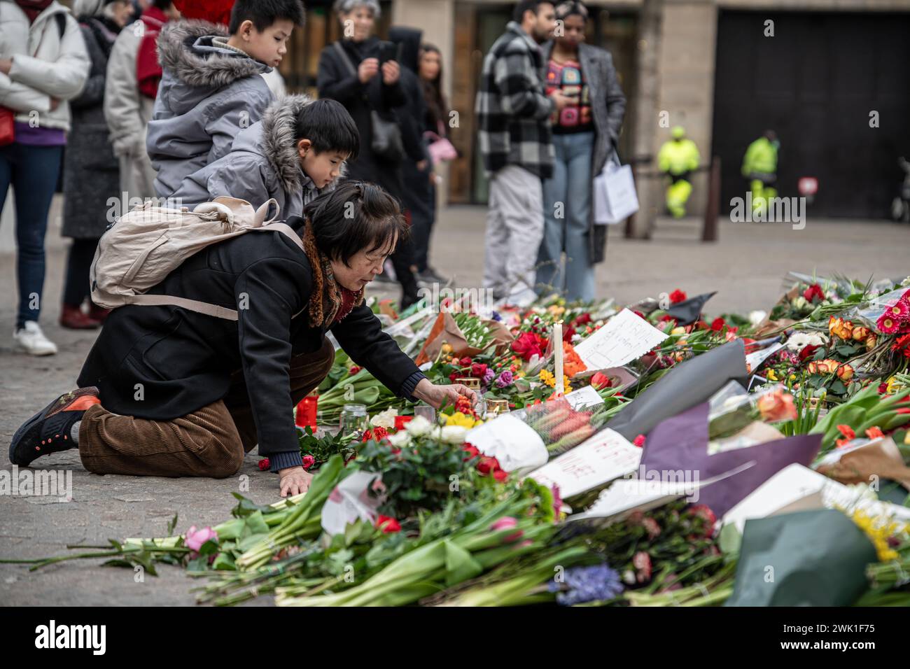 Amsterdam, the Netherlands - February 17, 2024: Chinese Woman Place Candle at Makeshift Memorial for Death of Alexei Navalny Stock Photo