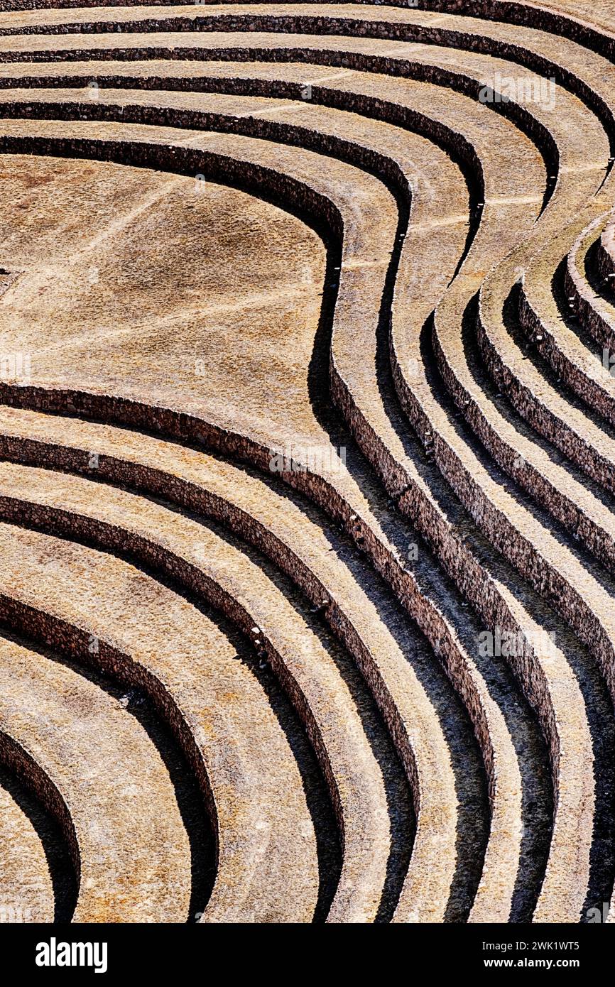 Bands of light and shadow from rock walls create an abstract background at the historic landmark Inca archaelogy site of Moray in Peru. Stock Photo