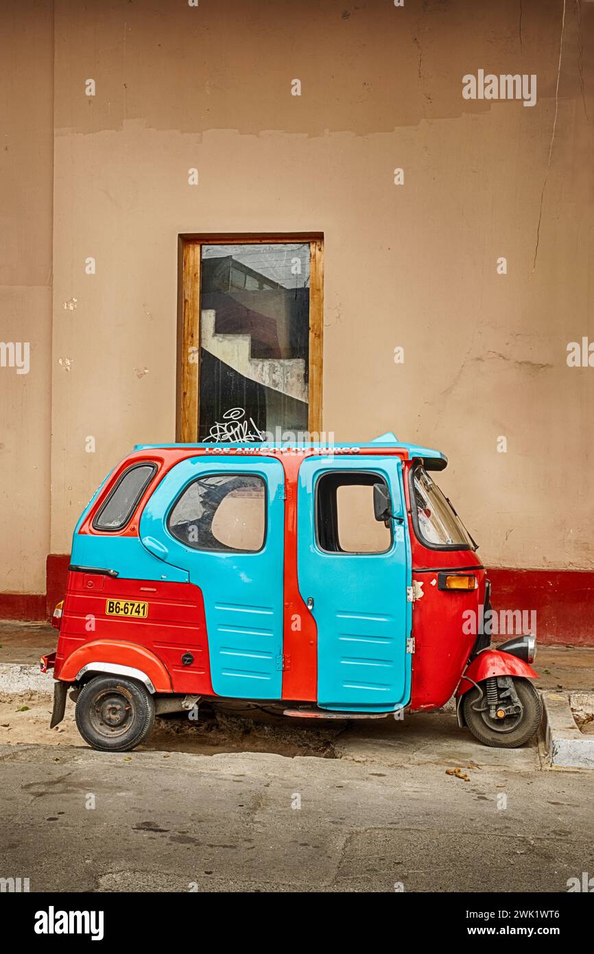A tiny blue and red delivery van is parked on a side street in the Barranco district of Lima, Peru. Stock Photo