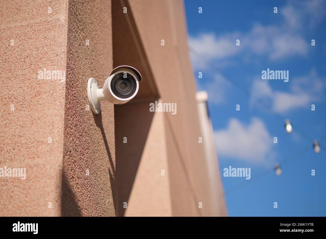 CCTV security camera operating on building against blue sky Stock Photo
