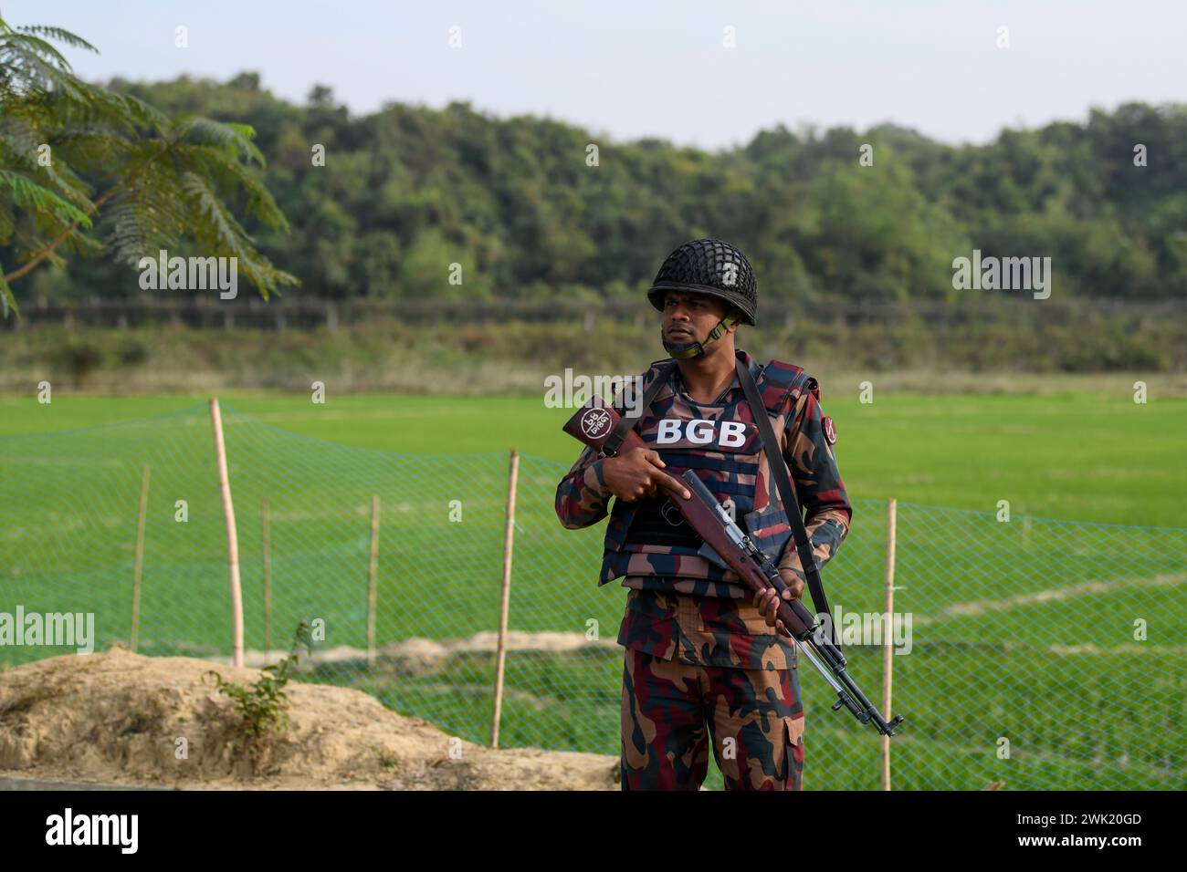 Bandarban, Bangladesh. 13th Feb, 2024. A member of the BGB stands on guard in the Naikhongchori area near the Bangladesh-Myanmar border in the Bandarban district of Bangladesh. The BGP's conflict with the Arakan Army, an armed rebel group inside Myanmar, continues unabated. Sustained firing, the sound of mortar shells bursting could be heard across the Bangladesh-Myanmar border area. Bullets and mortar shells fired from Myanmar are coming across the border in the towns of Bangladesh. Credit: SOPA Images Limited/Alamy Live News Stock Photo