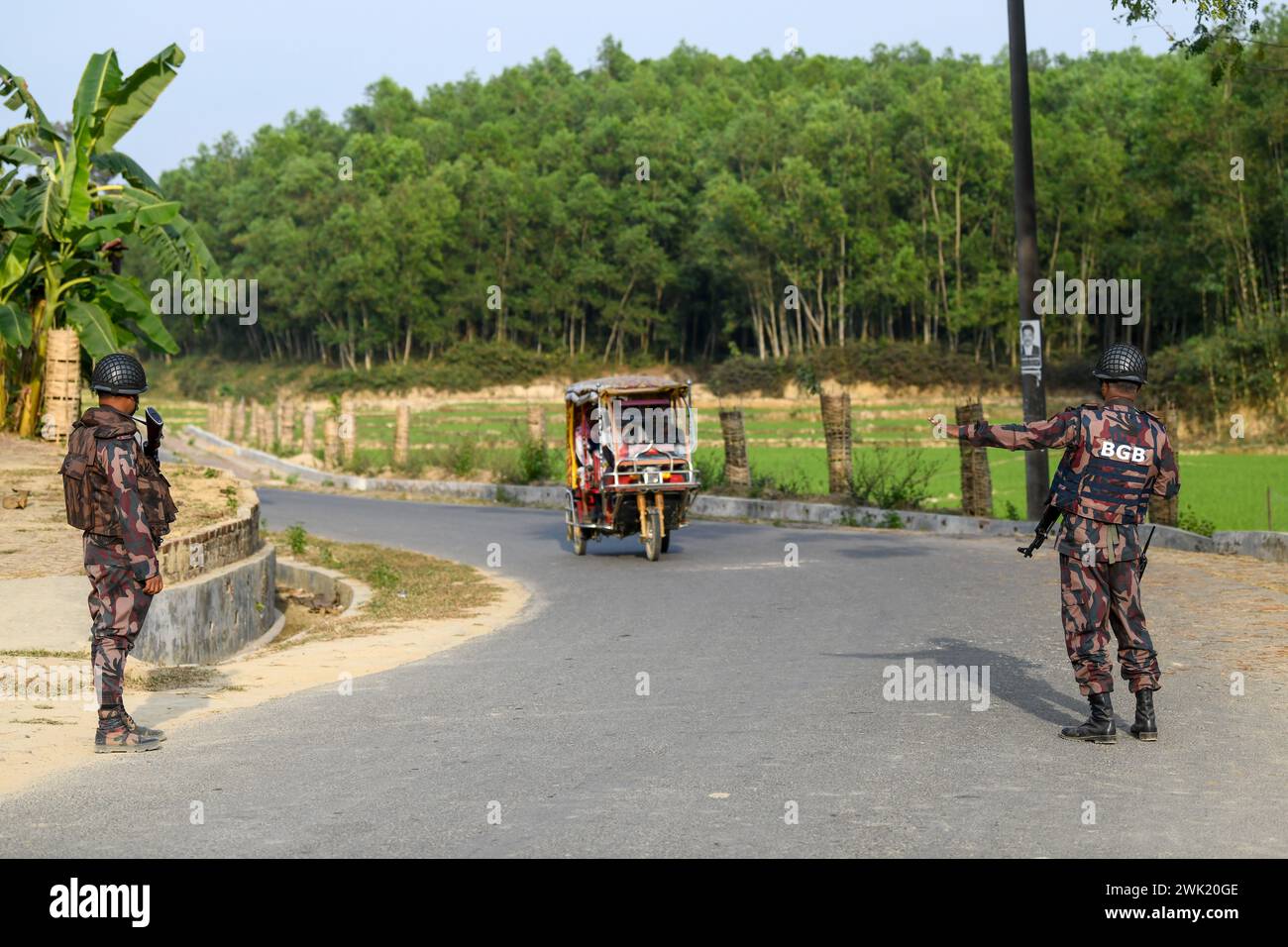 Bandarban, Bangladesh. 13th Feb, 2024. Members of the BGB stops a civilian for check up in the Naikhongchori area near the Bangladesh-Myanmar border in the Bandarban district of Bangladesh. The BGP's conflict with the Arakan Army, an armed rebel group inside Myanmar, continues unabated. Sustained firing, the sound of mortar shells bursting could be heard across the Bangladesh-Myanmar border area. Bullets and mortar shells fired from Myanmar are coming across the border in the towns of Bangladesh. Credit: SOPA Images Limited/Alamy Live News Stock Photo