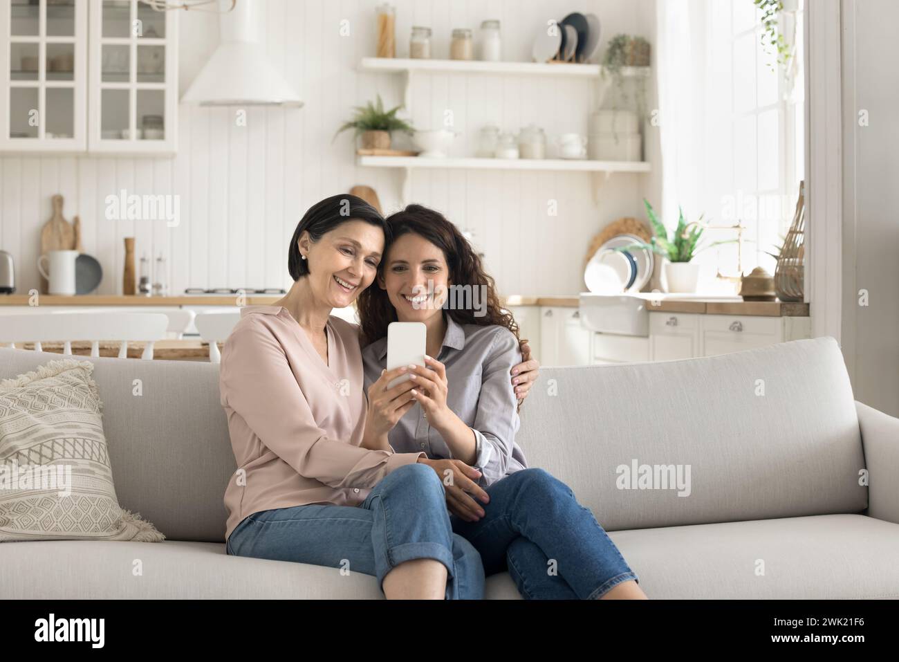 Happy mother and daughter using smart phone Stock Photo