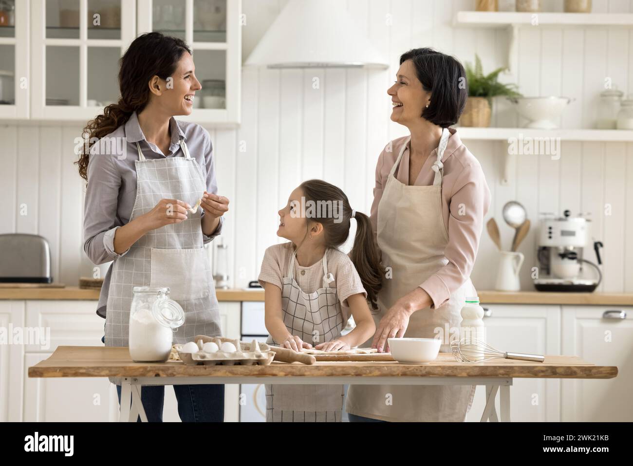 Child wear apron cooking with mom and granny in kitchen Stock Photo - Alamy