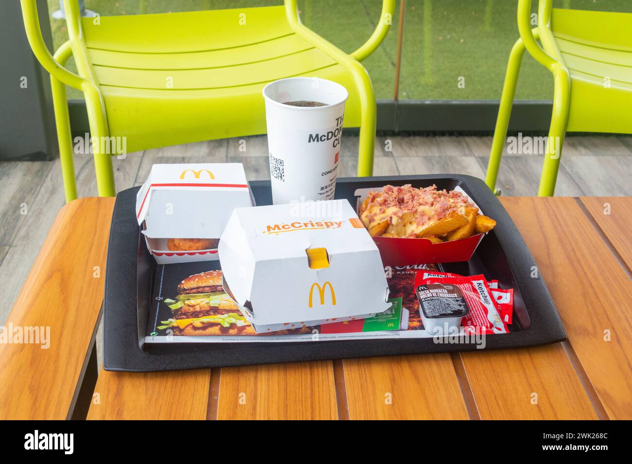 Aranda de Duero, Spain - September 16, 2023: McDonald's menu with McCrispy BBQ with bacon, Top Fries with bacon and cheese deluxe, McNuggets and Coca- Stock Photo