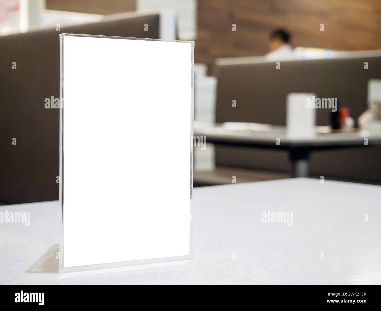 Mock up menu frame on table in the cafe restaurant, acrylic stand with white paper Stock Photo