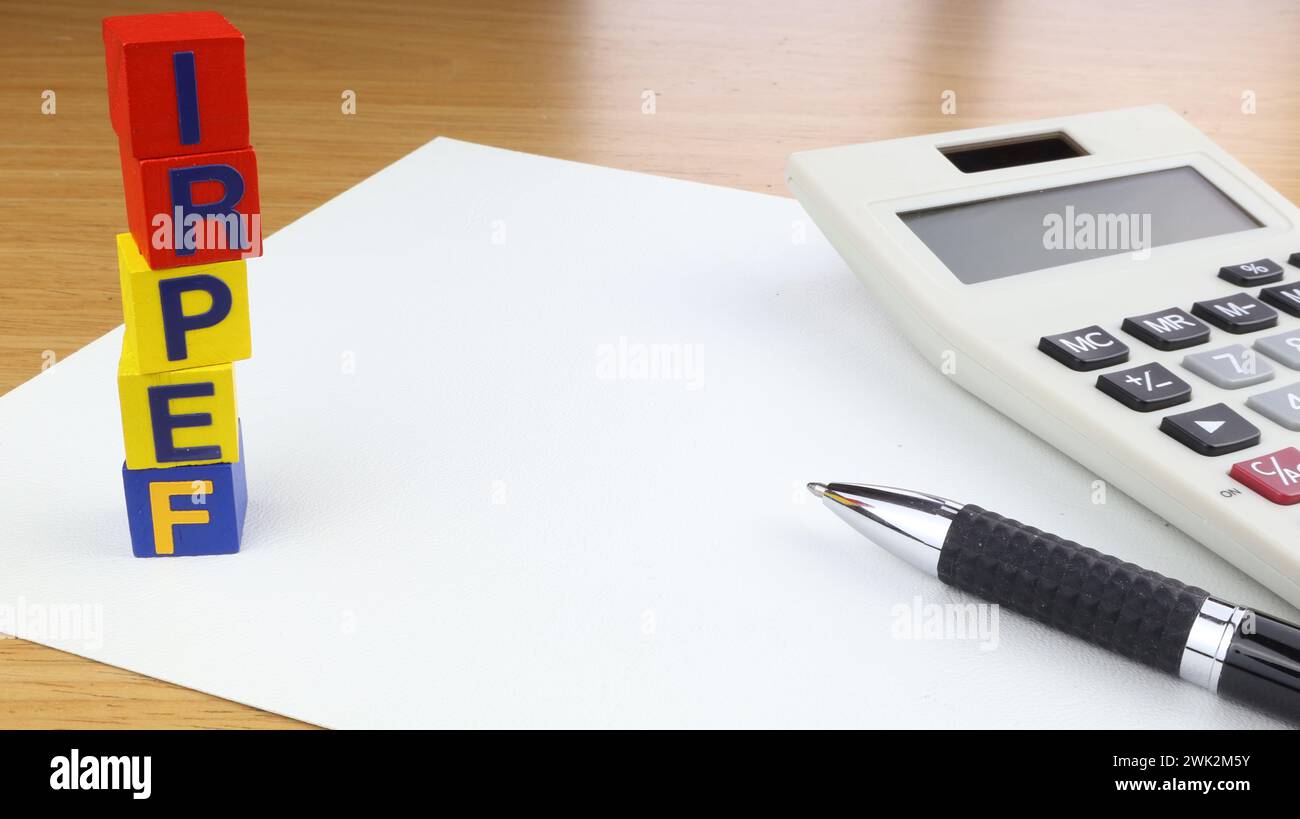 Writing IRPEF income tax letters on wooden cubes With pen and calculator desk background. Stock Photo