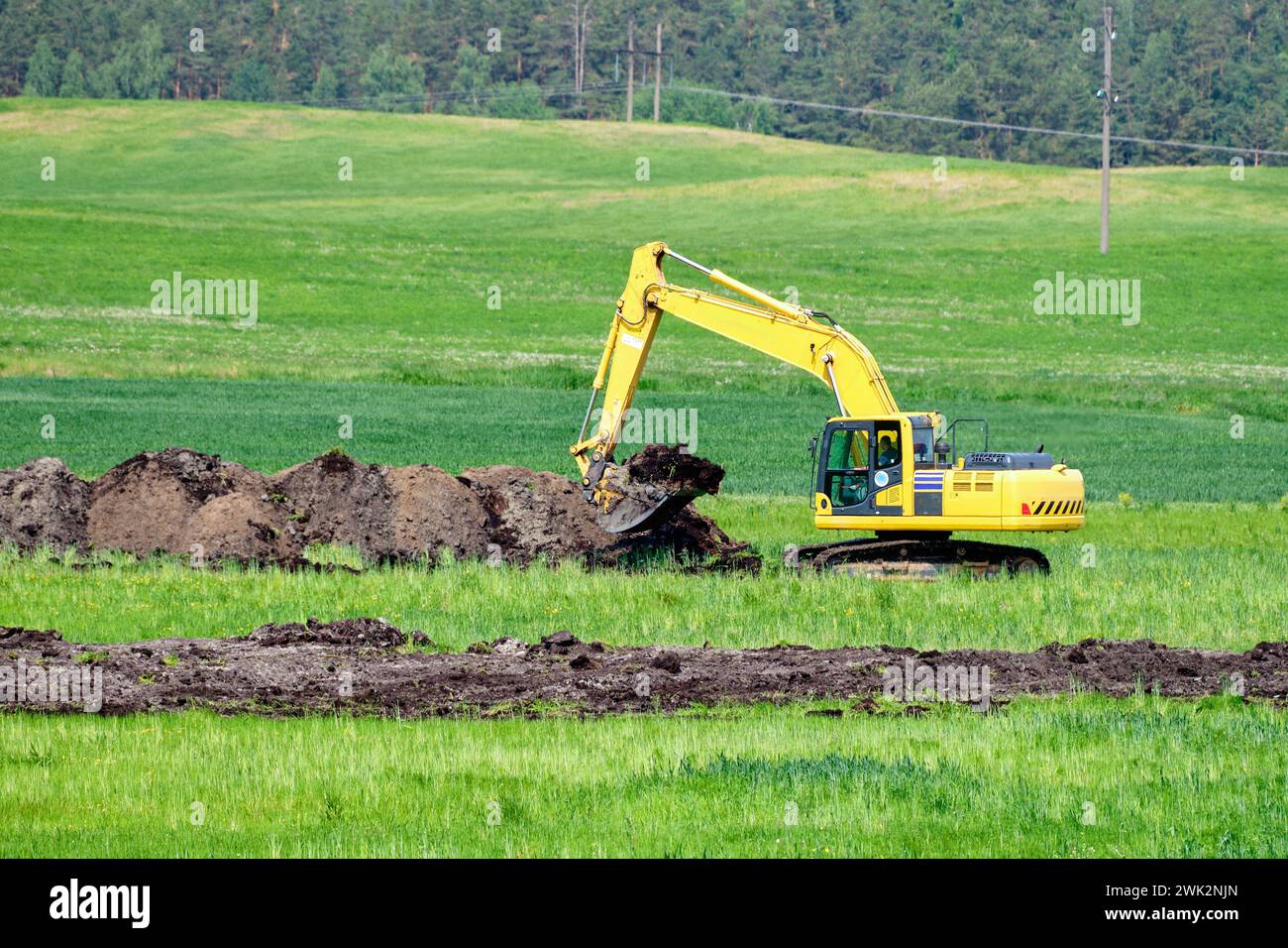 An excavator digs a trench to lay pipes in the soil Stock Photo - Alamy
