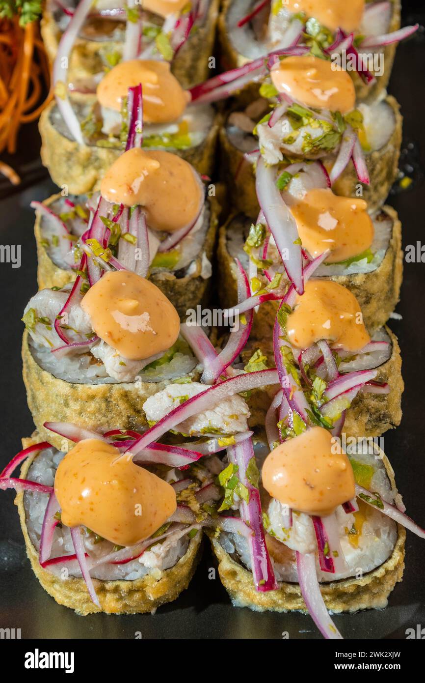 A vertical of sushi roll with salmon and Sriracha mayo sauce Stock Photo