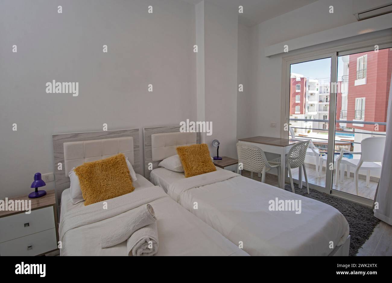 Interior design decor furnishing of luxury show home bedroom showing furniture and twin beds with balcony Stock Photo