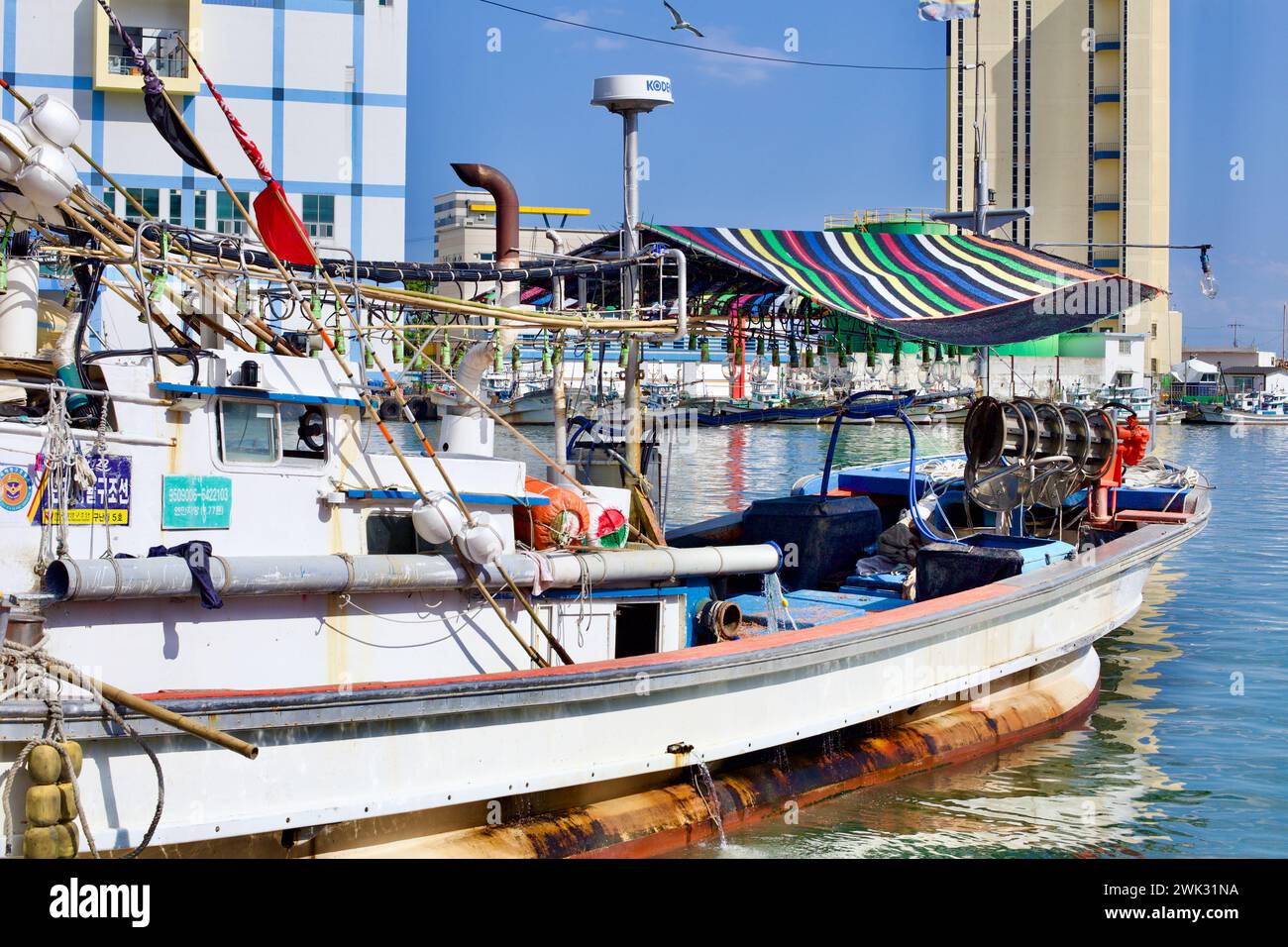 Donghae City, South Korea - July 28th, 2019: A quaint, small squid fishing boat at Mukho Port, decked with large lightbulbs for night fishing, sets a Stock Photo