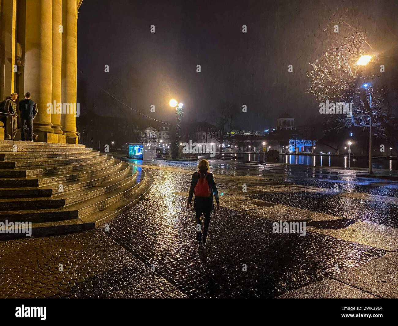 Eine Frau geht in der Nacht allein durch den Schlossgarten in Stuttgart Stock Photo