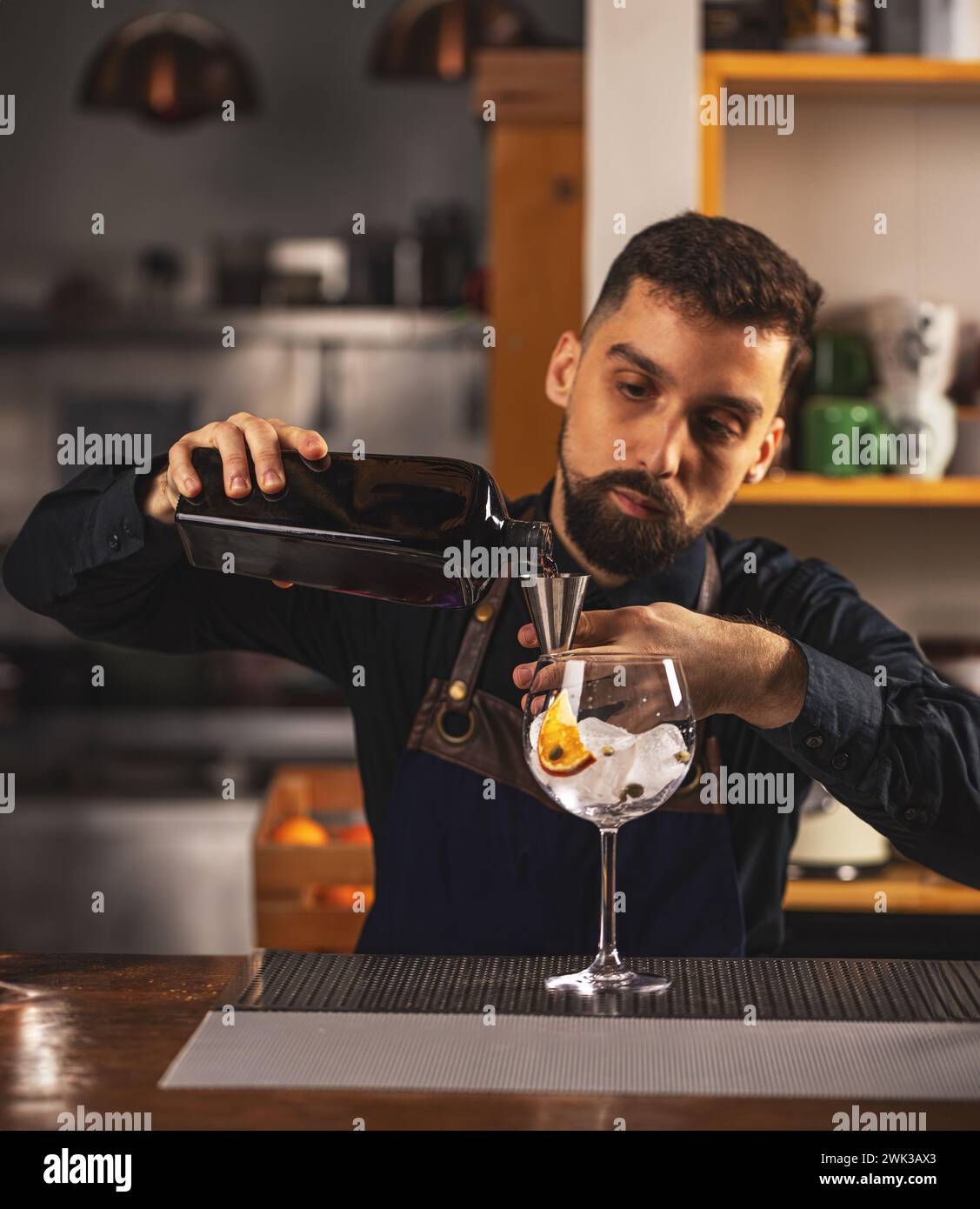 Professional barman using double cocktail jigger pouring alcohol drink Stock Photo