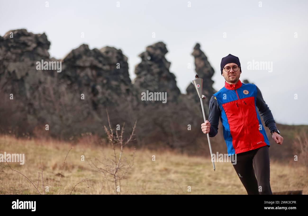 18 February 2024, Saxony-Anhalt, Weddersleben: Arne Peters from the Harz mountain rescue service runs along the Devil's Wall near Weddersleben with a torch bearing the light of hope. The 'Light of Hope and Humanity' was lit for the first time in Saxony-Anhalt during this year's torch relay (Italian: 'Fiaccolata') to Solferino in Italy. Helpers and volunteers from the German Red Cross will carry the light through the state for 10 days until February 23, 2024 and draw attention to the campaign. Photo: Matthias Bein/dpa Stock Photo