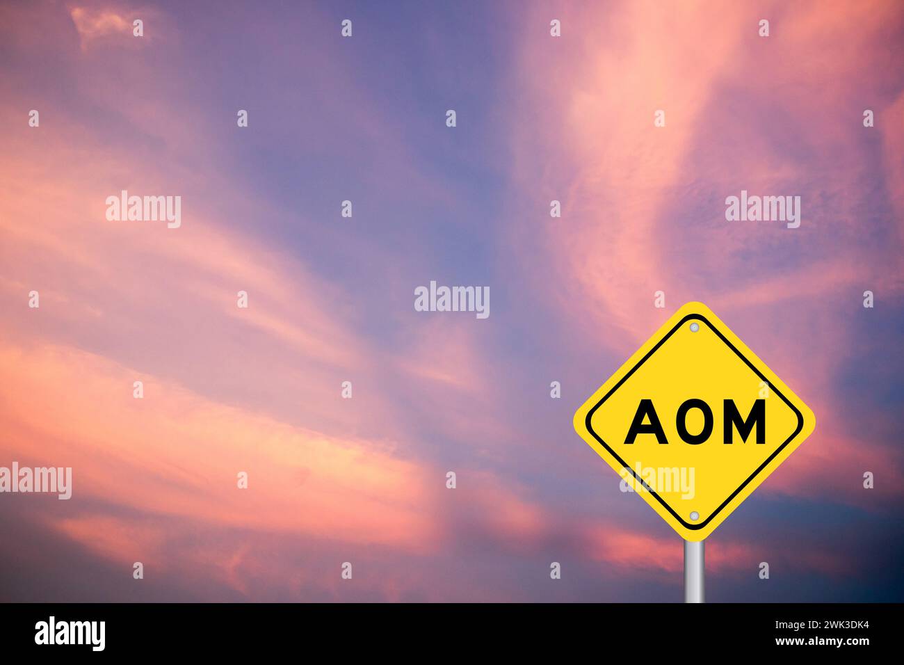 Yellow transportation sign with word AOM (Abbreviation of Advanced order management, add on module or assistant operation manager) on violet color sky Stock Photo