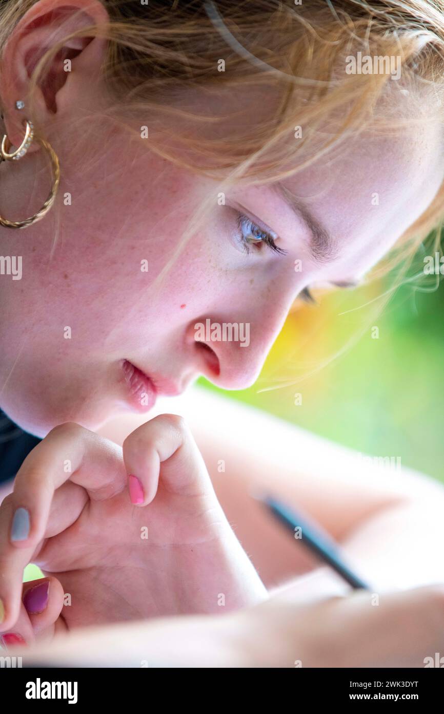 Girl concentrating while writing Stock Photo