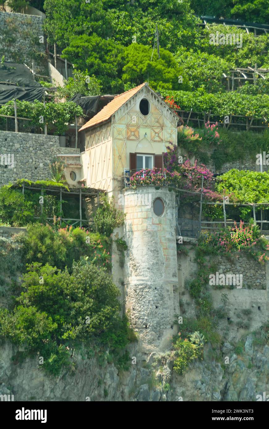 One isolated detached cliff home built on large cylindrical concrete column on top of similar waterside clif rock foundation cylindrical concrete column seen from passing motorboat on the Tyrrhenian Sea & Gulf of Salerno part of Amalfi Unesco coastline heritage area very near to Amalfi town in Campania southern Italy in a historical archive image. Stock Photo