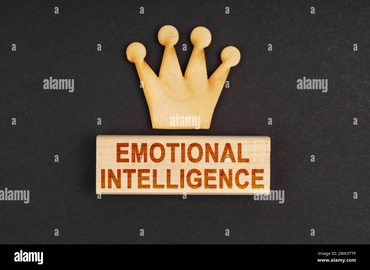 Leader concept. On a black surface there is a wooden crown and a block with the inscription - Emotional intelligence Stock Photo